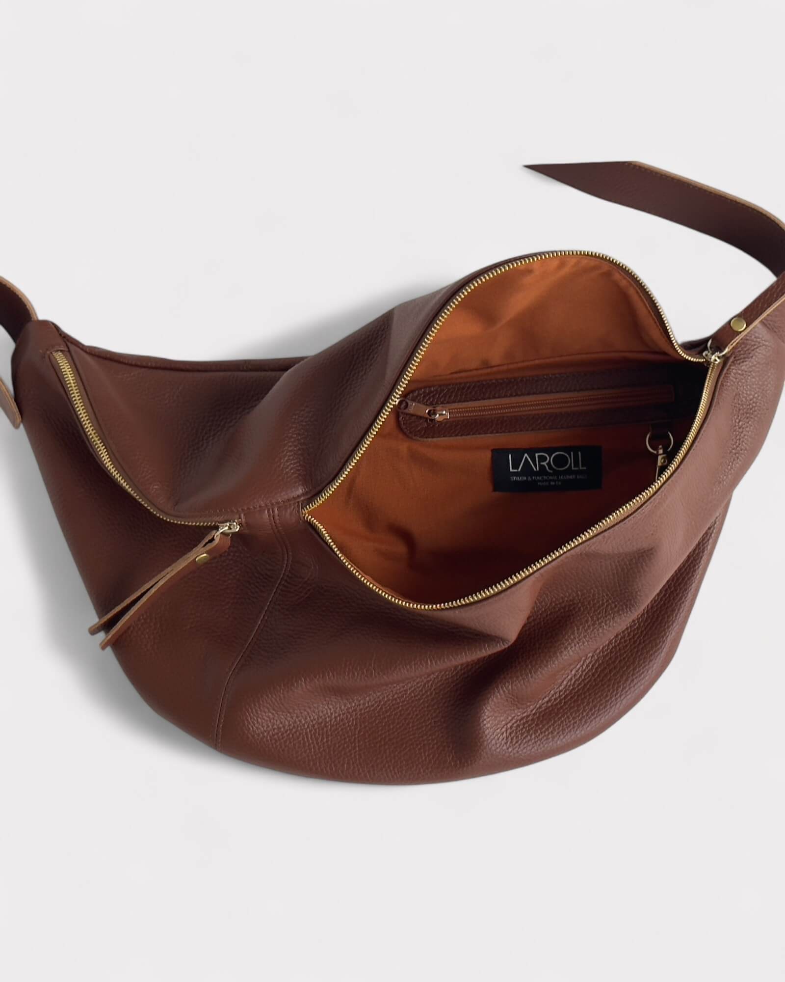 Brown leather handbag lining with visible brand logo on a light gray background