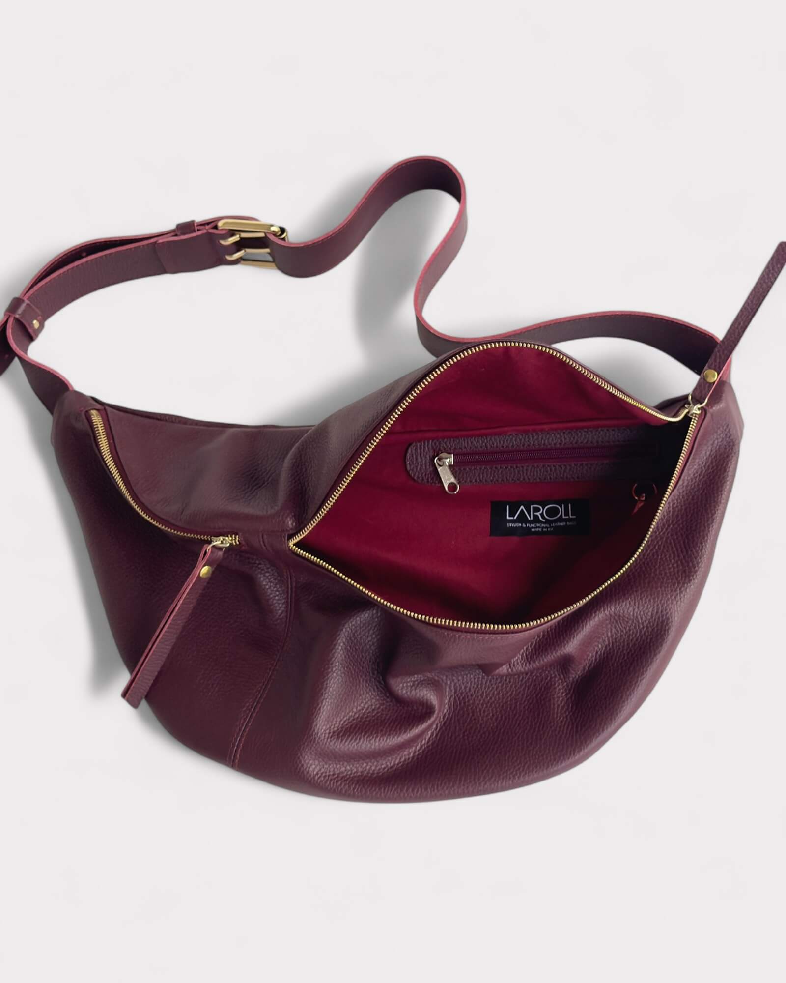 Burgundy handbag with gold zipper on a white background