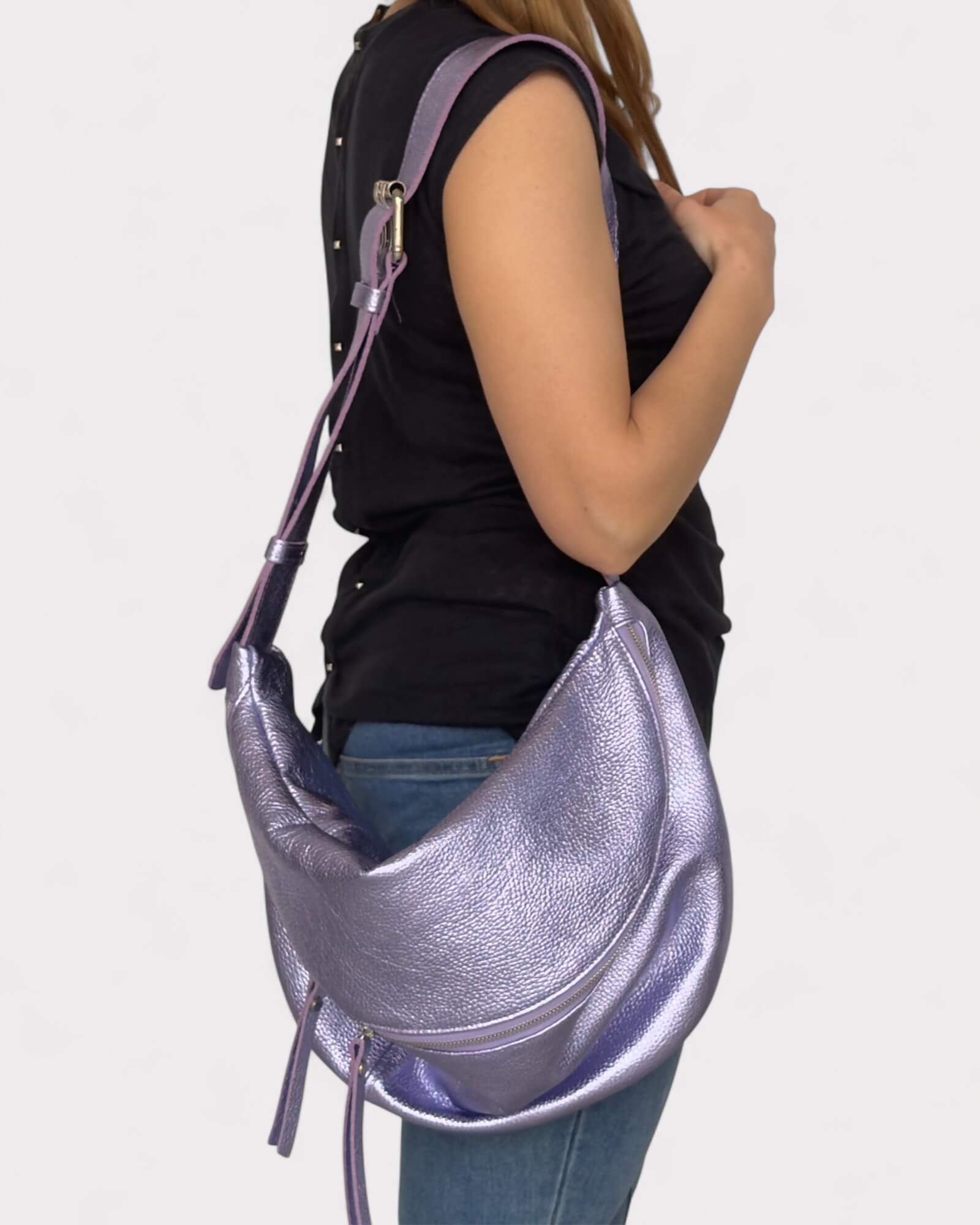 Person holding a lilac metallic chest bag against a white background