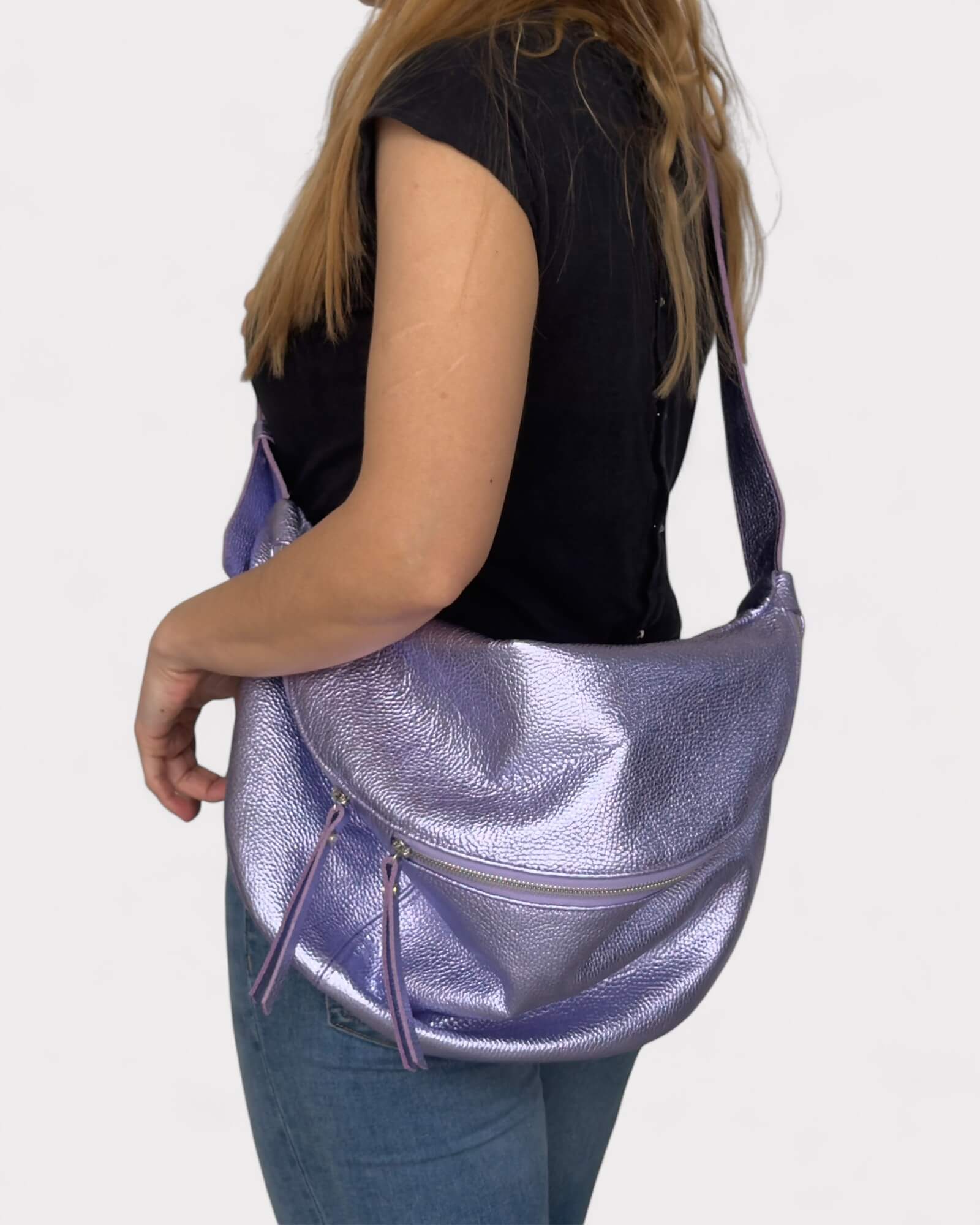 Person holding a purple metallic handbag against a white background