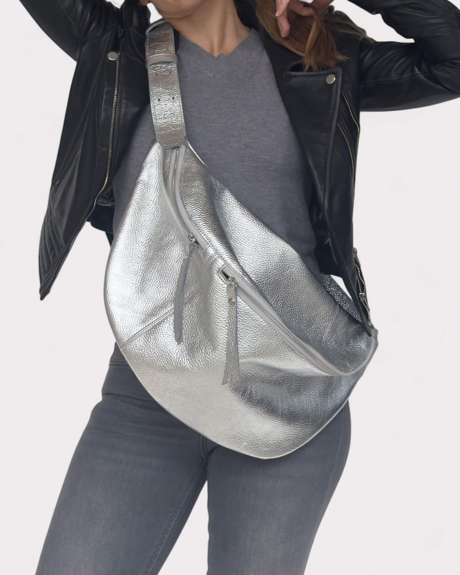 Person wearing a silver fanny pack with a plain background