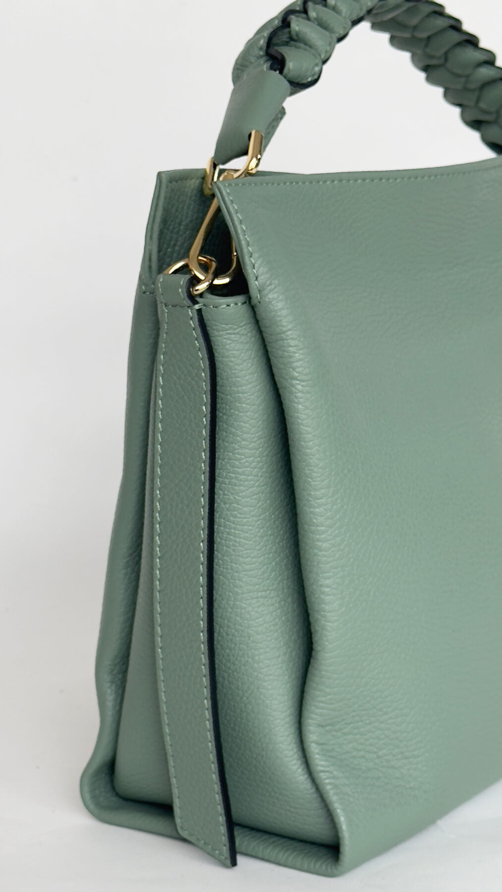 Green handbag with a gold zipper on a white background