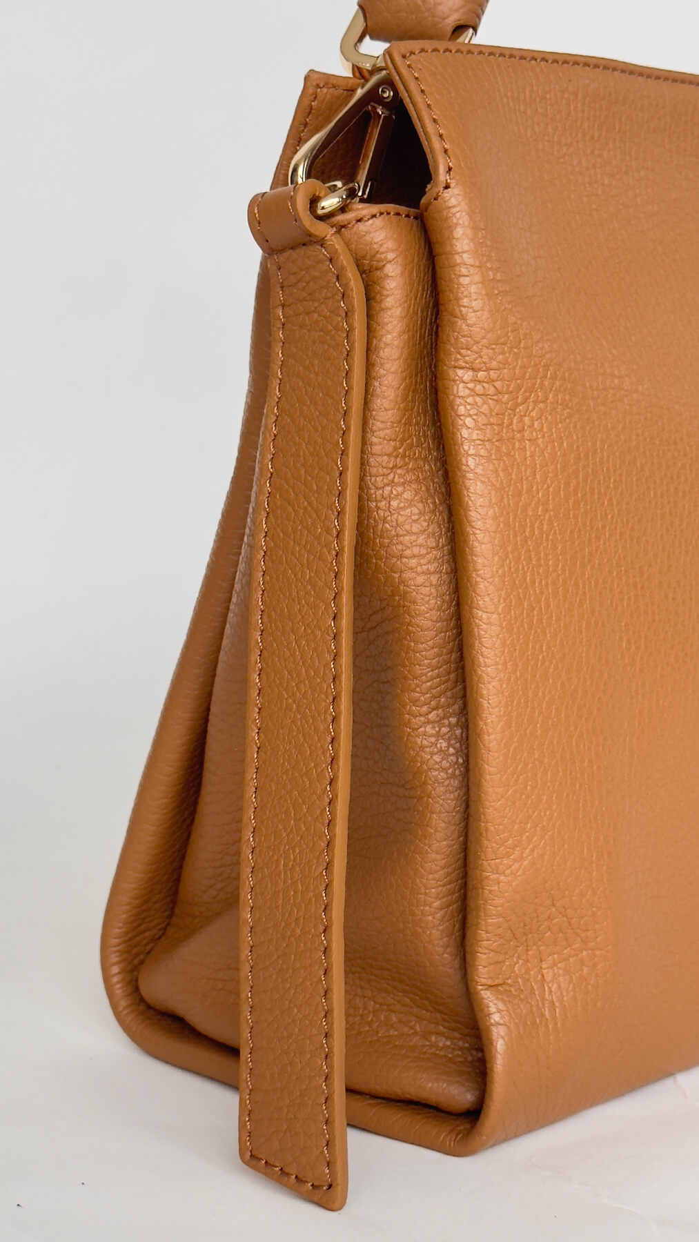 Tan leather handbag on a light gray background