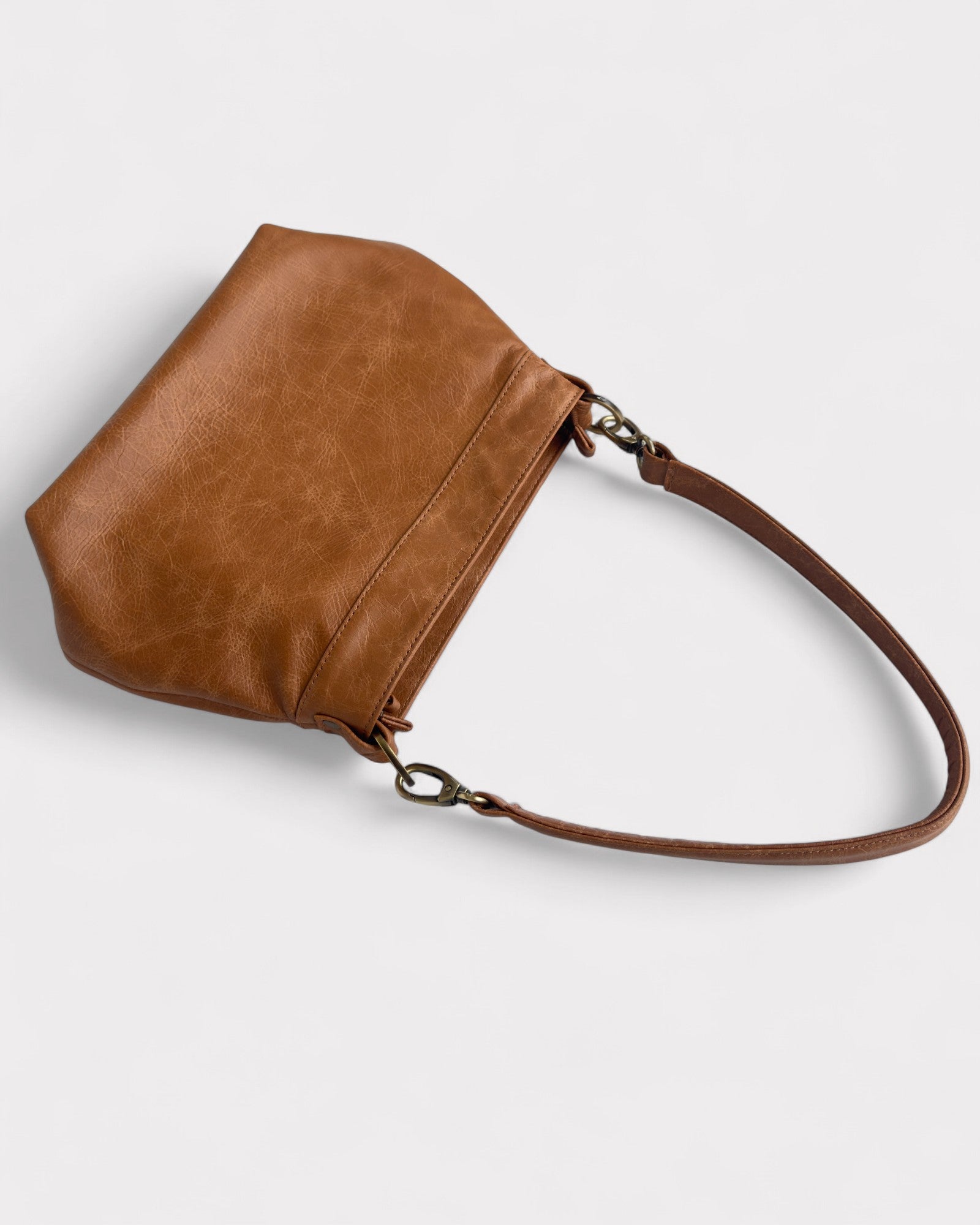 tan distressed leather handbag on a light gray background