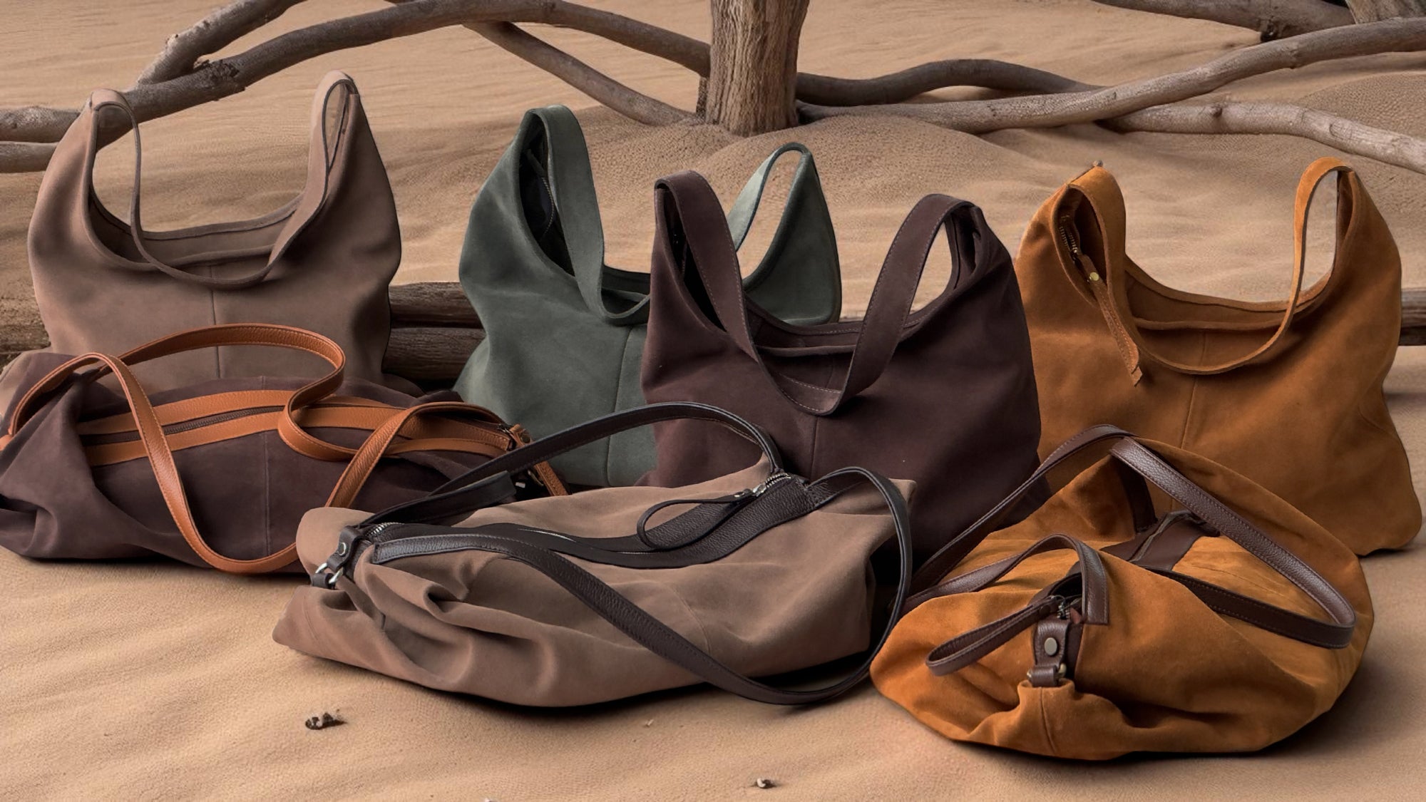 Set of suede leather bags on a wooden surface with branches in the background