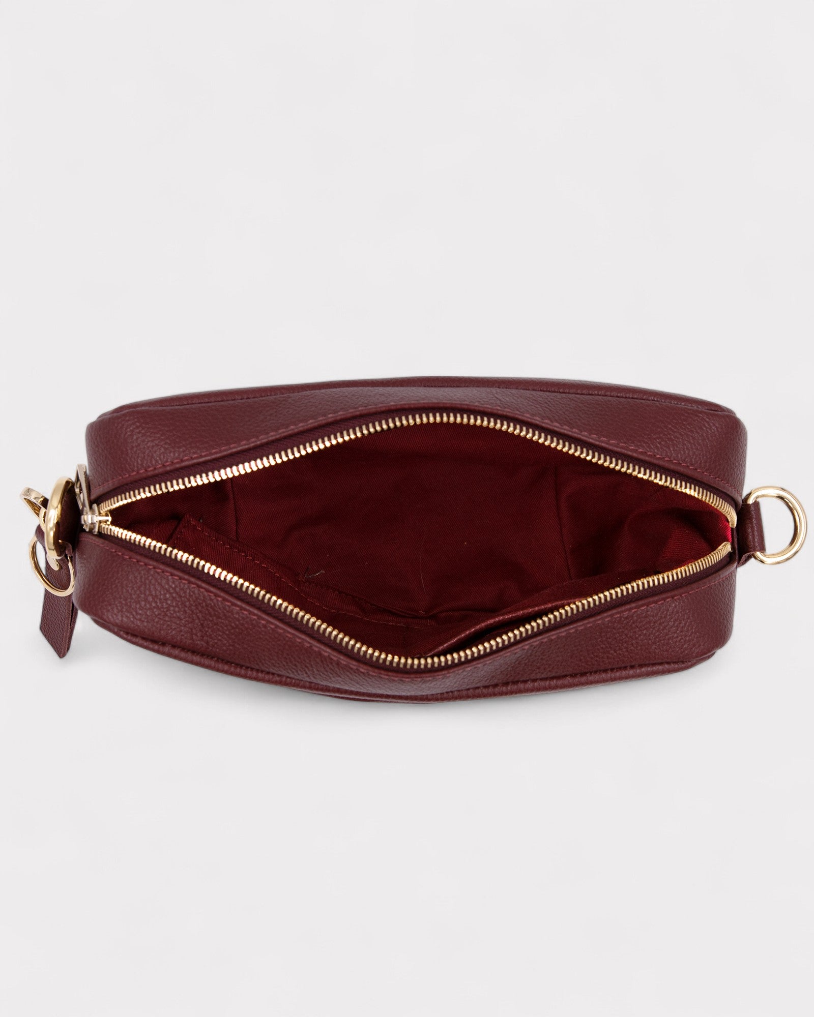 Burgundy leather bag with gold zipper on a white background
