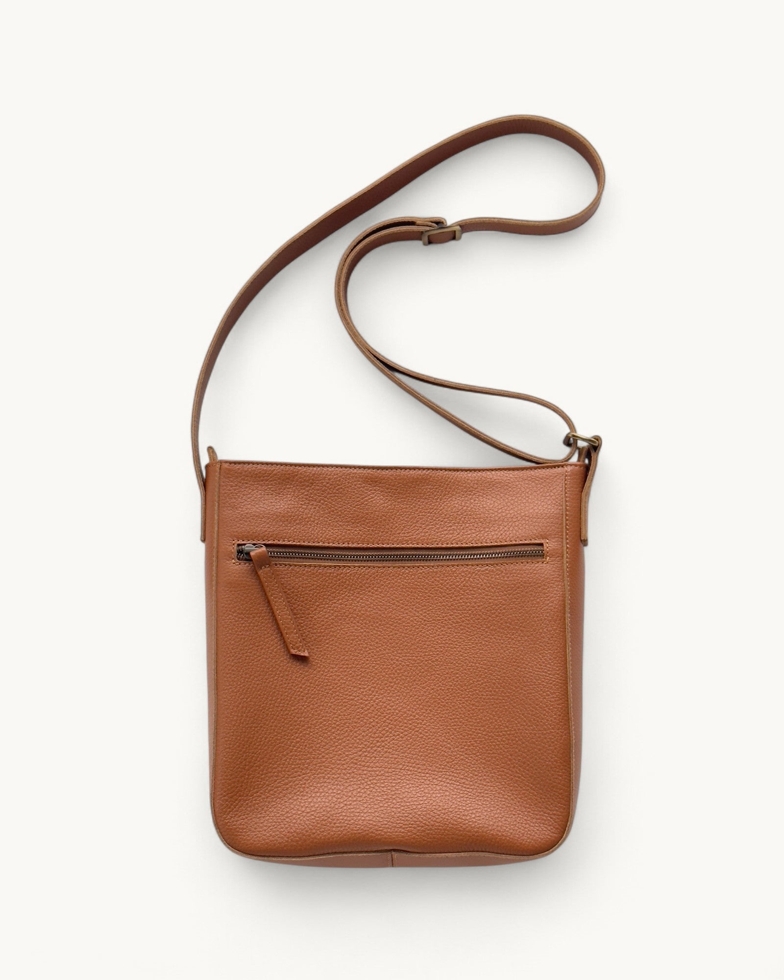 Tan leather crossbody bag on a white background