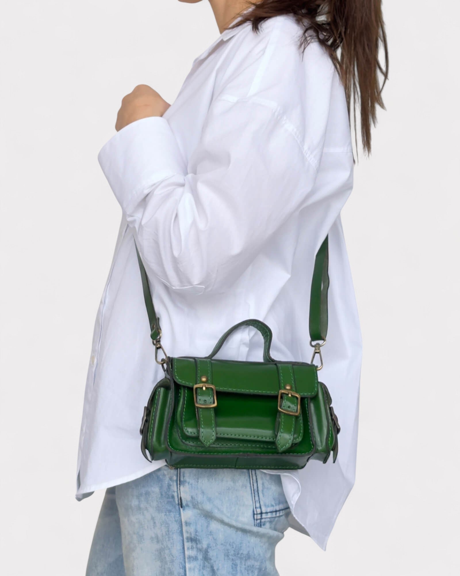 model carrying green satchel crossbody bag side view