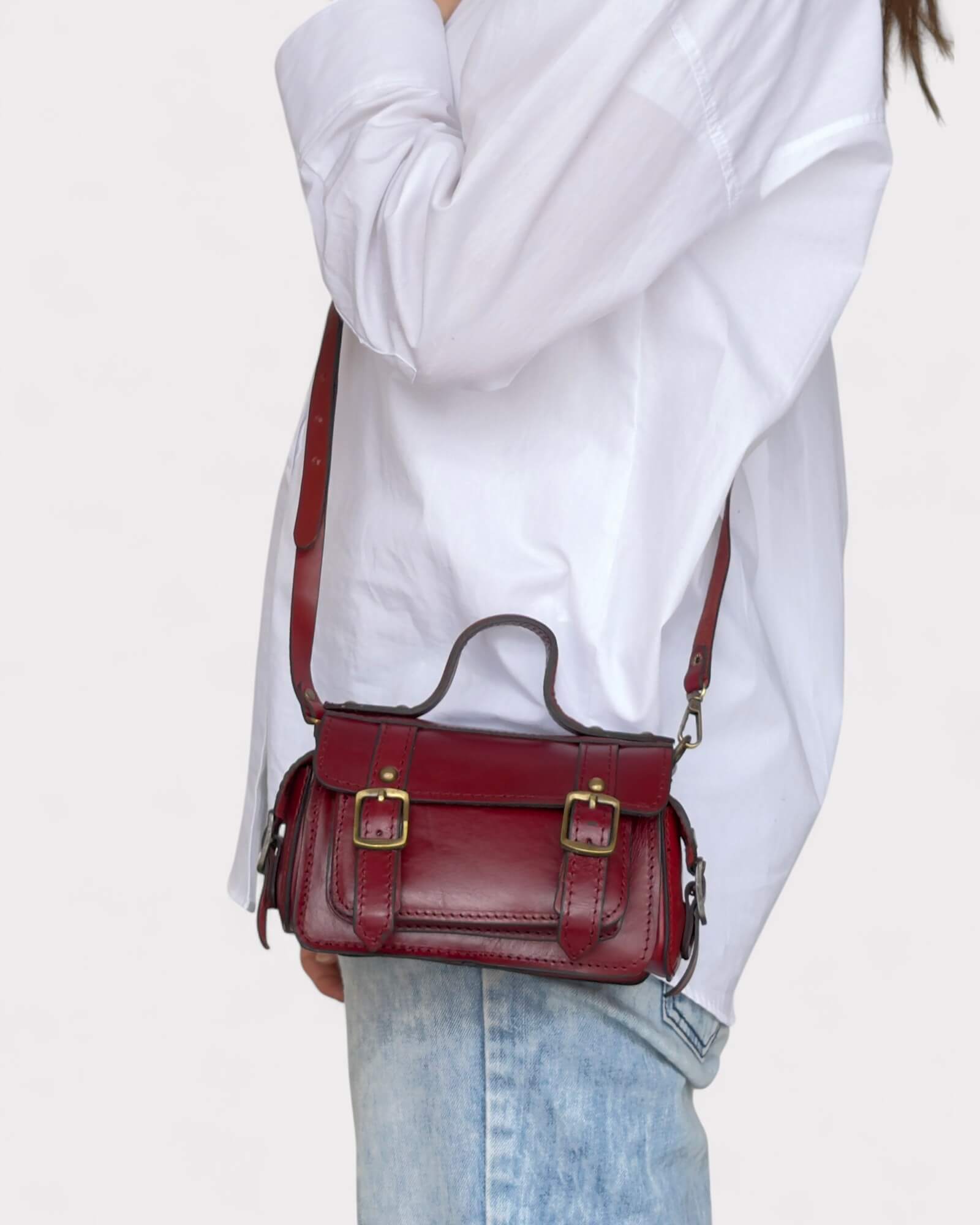 model carrying red crossbody satchel side view