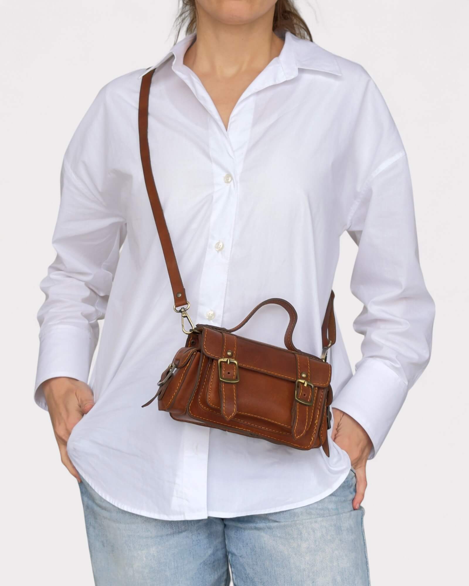 model carrying the brown crossbody satchel across the body
