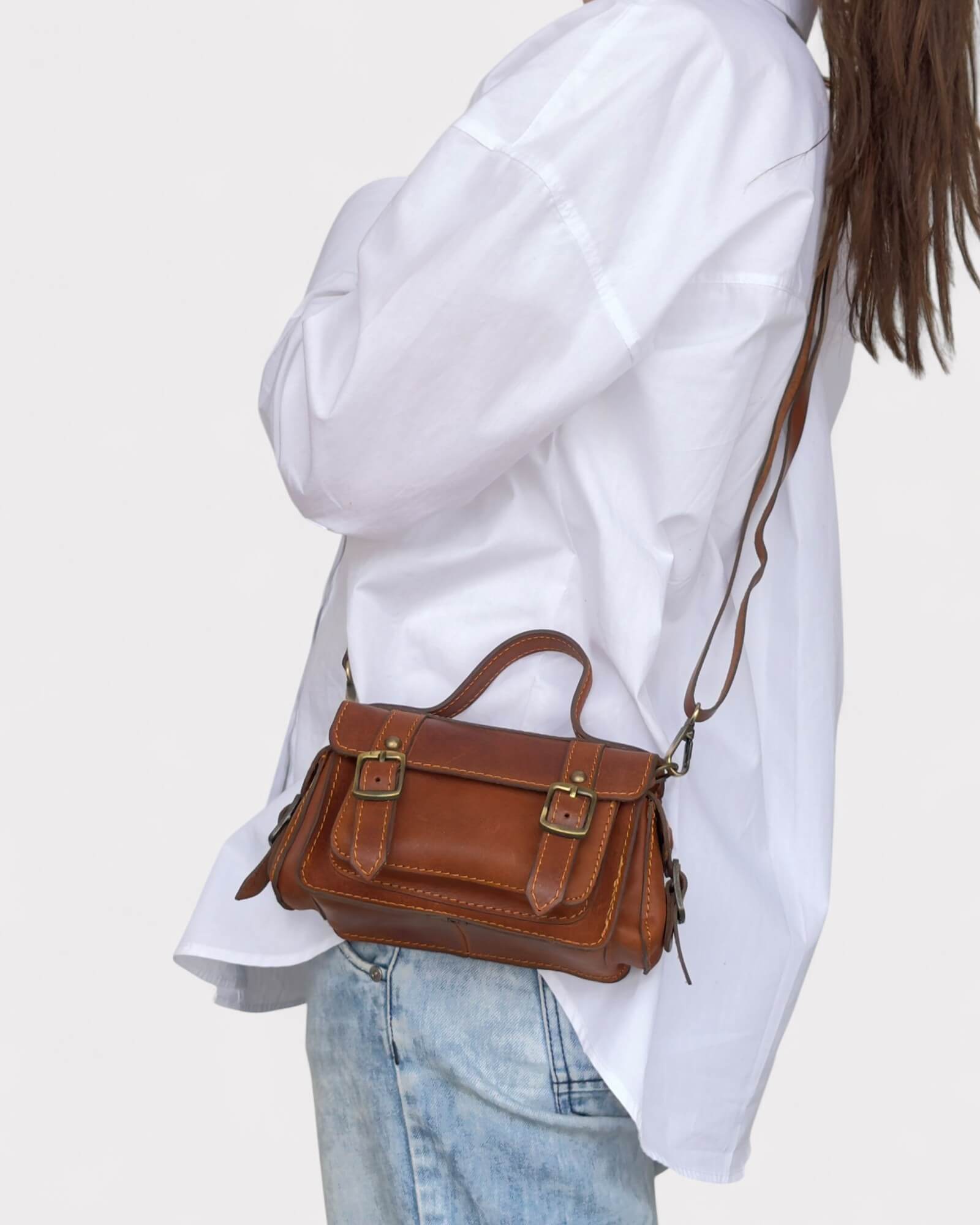model carrying the brown crossbody satchel side view