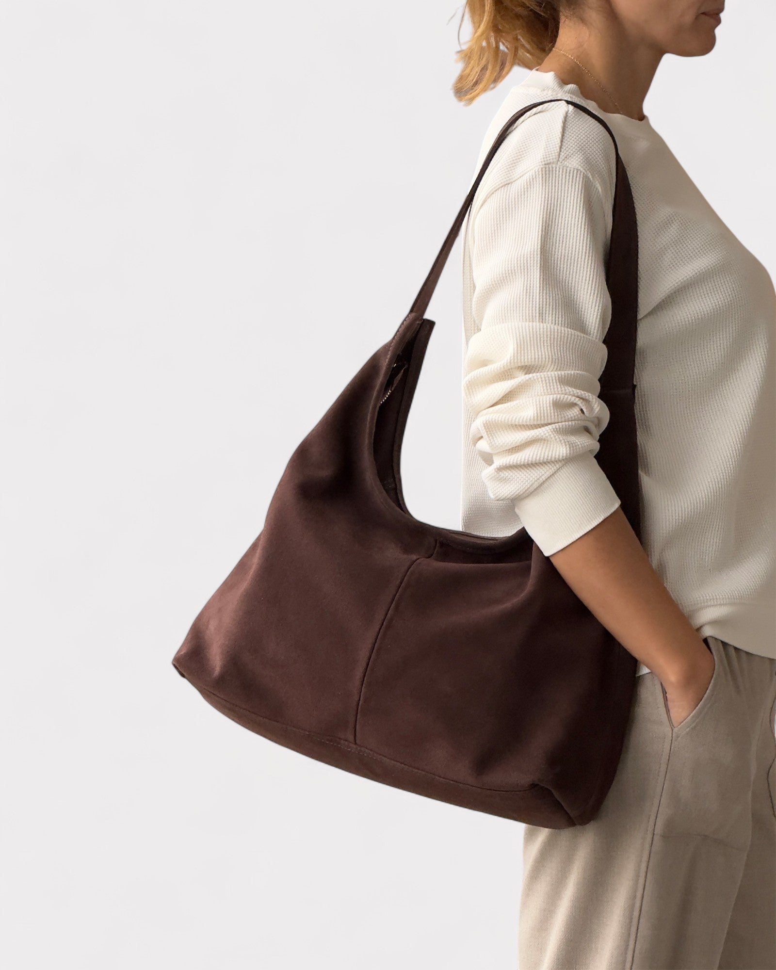 girl wearing dark brown suede purse