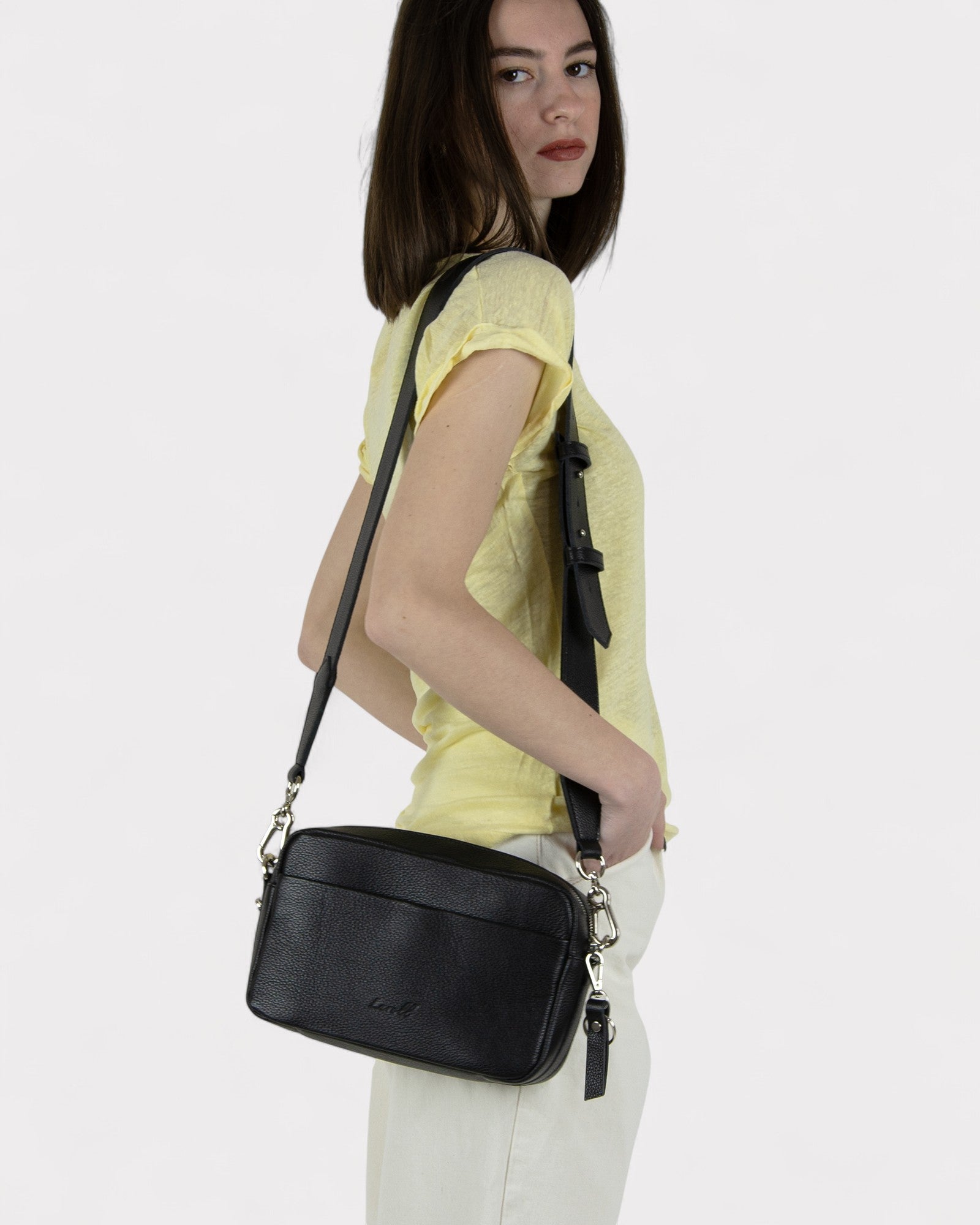 Woman holding a black handbag against a white background