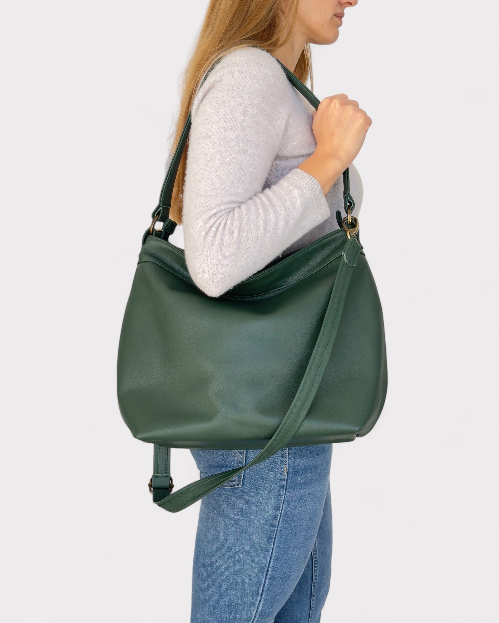 Person wearing a green shoulder bag on a plain background