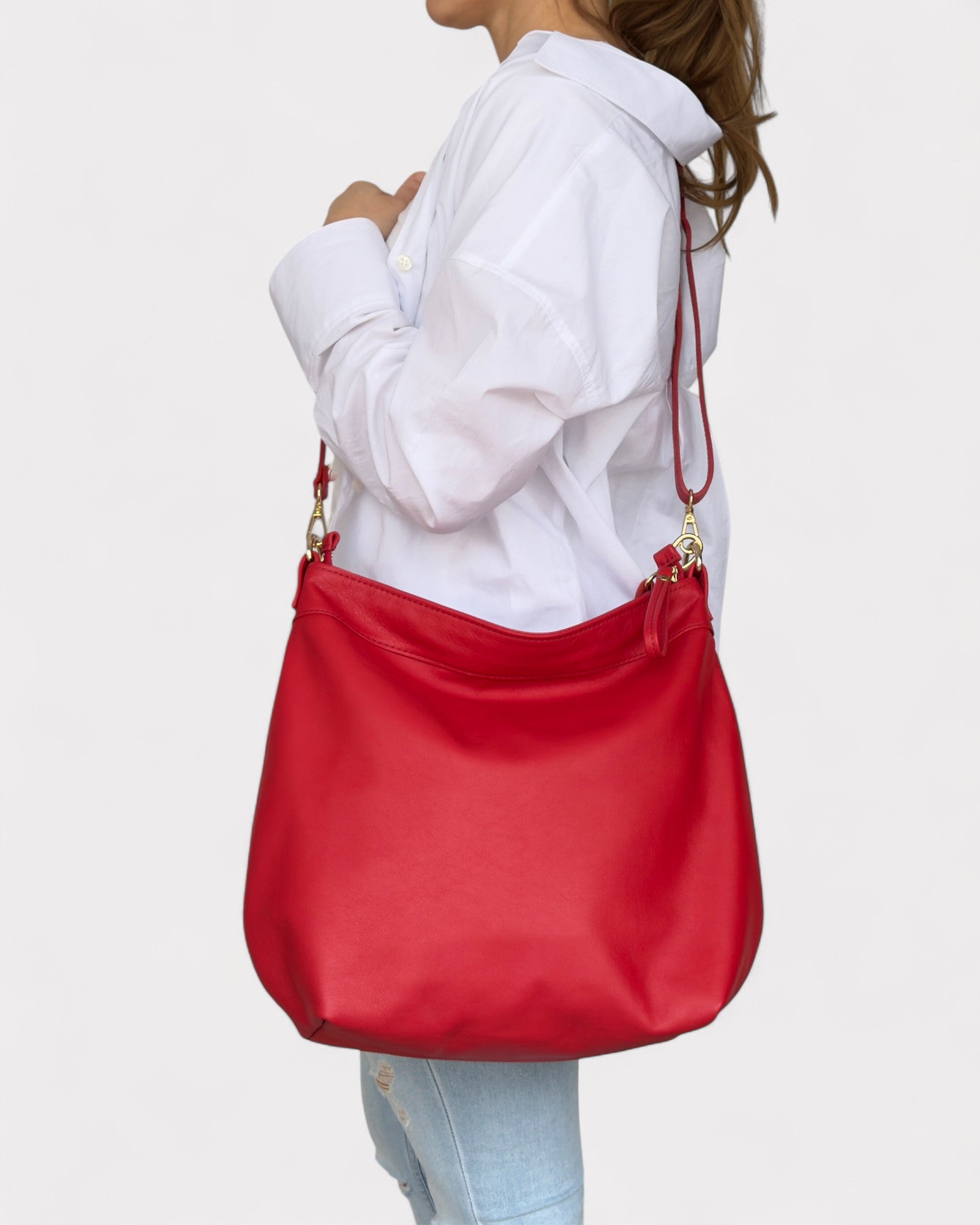 Red handbag worn by a person on a light gray background