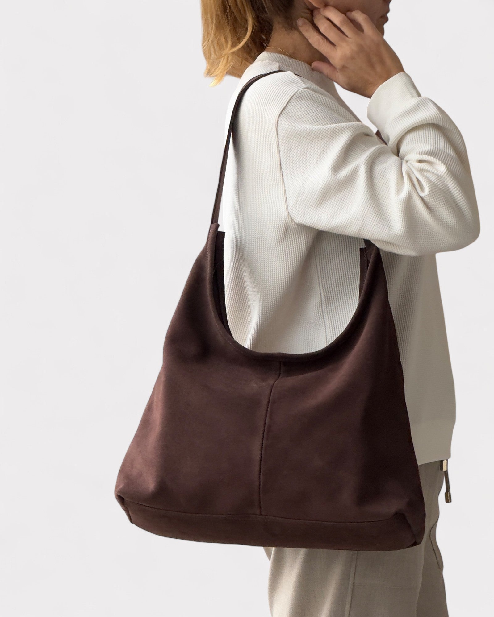 girl wearing dark brown suede handbag on shoulder