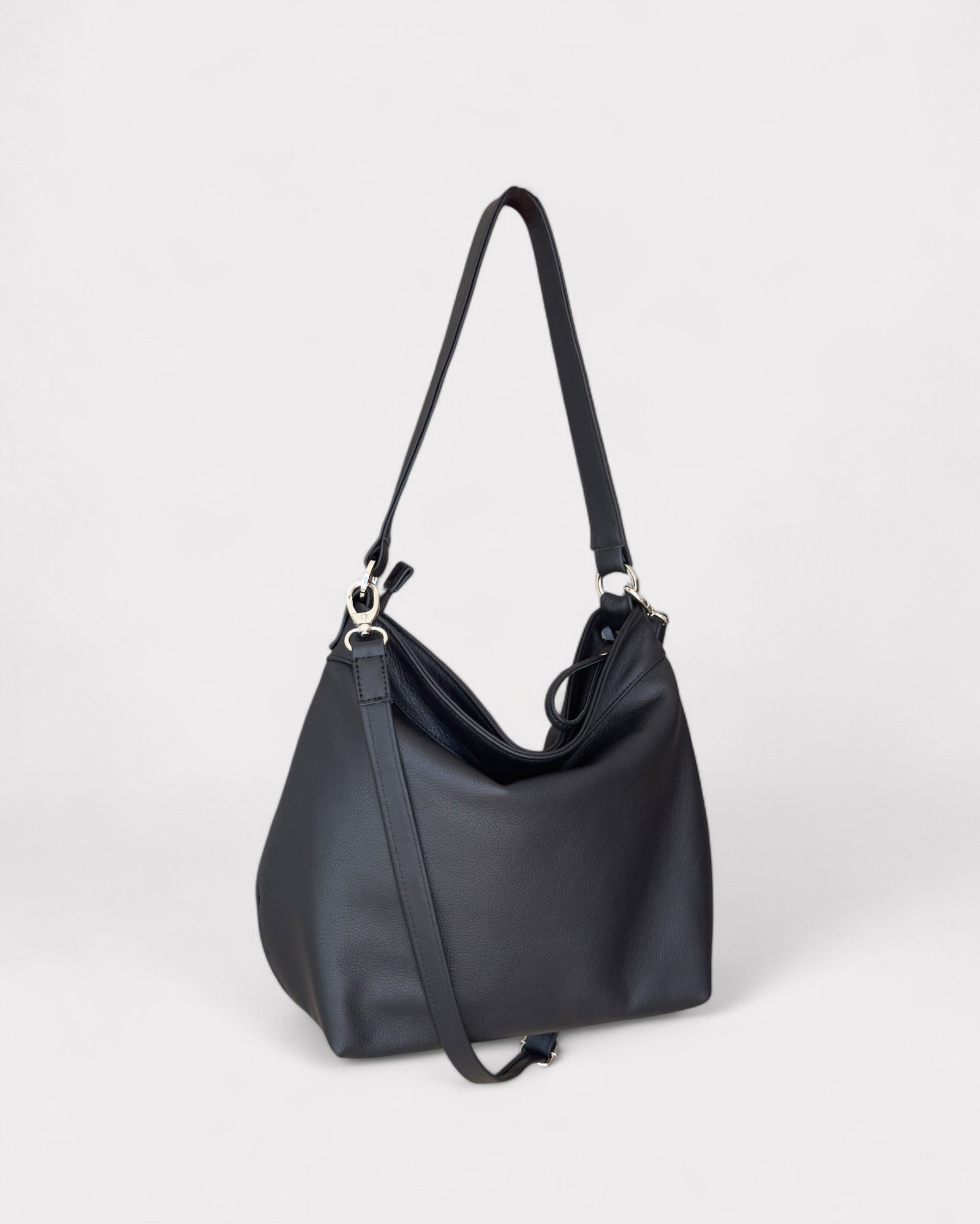 Black handbag with a shoulder strap on a light gray background