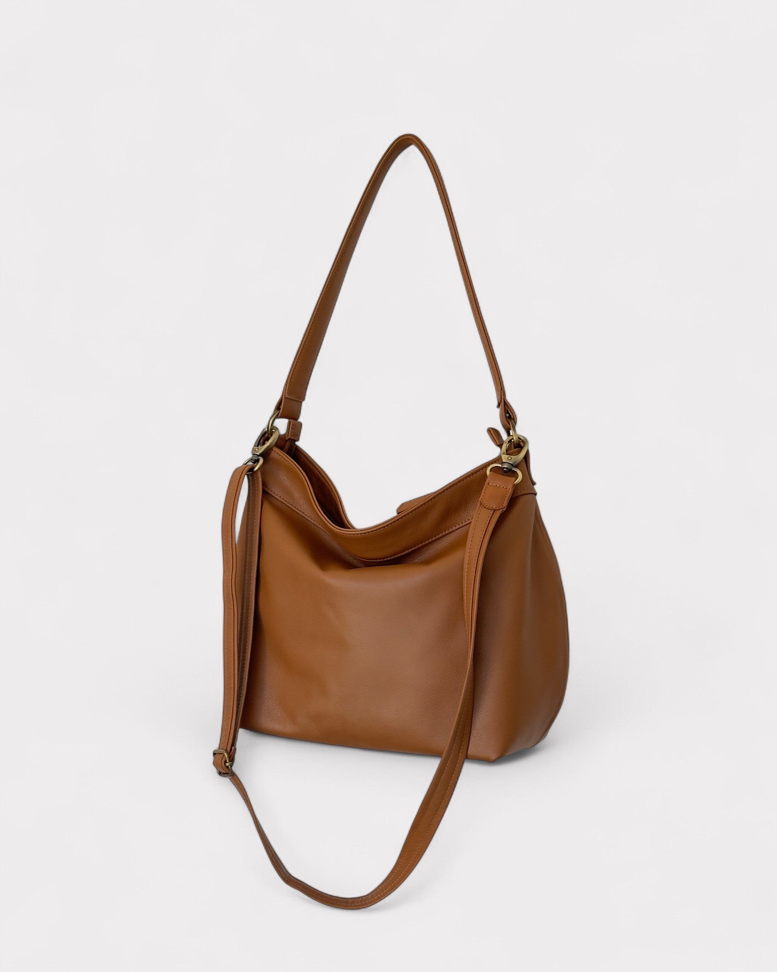 Tan leather handbag with a shoulder strap on a white background