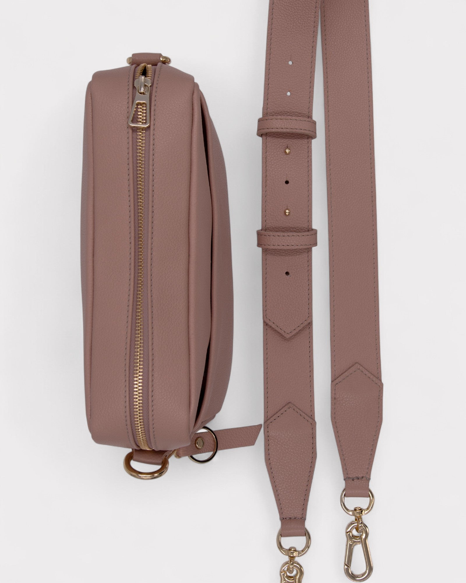 dusty rose leather bag with a strap on a white background