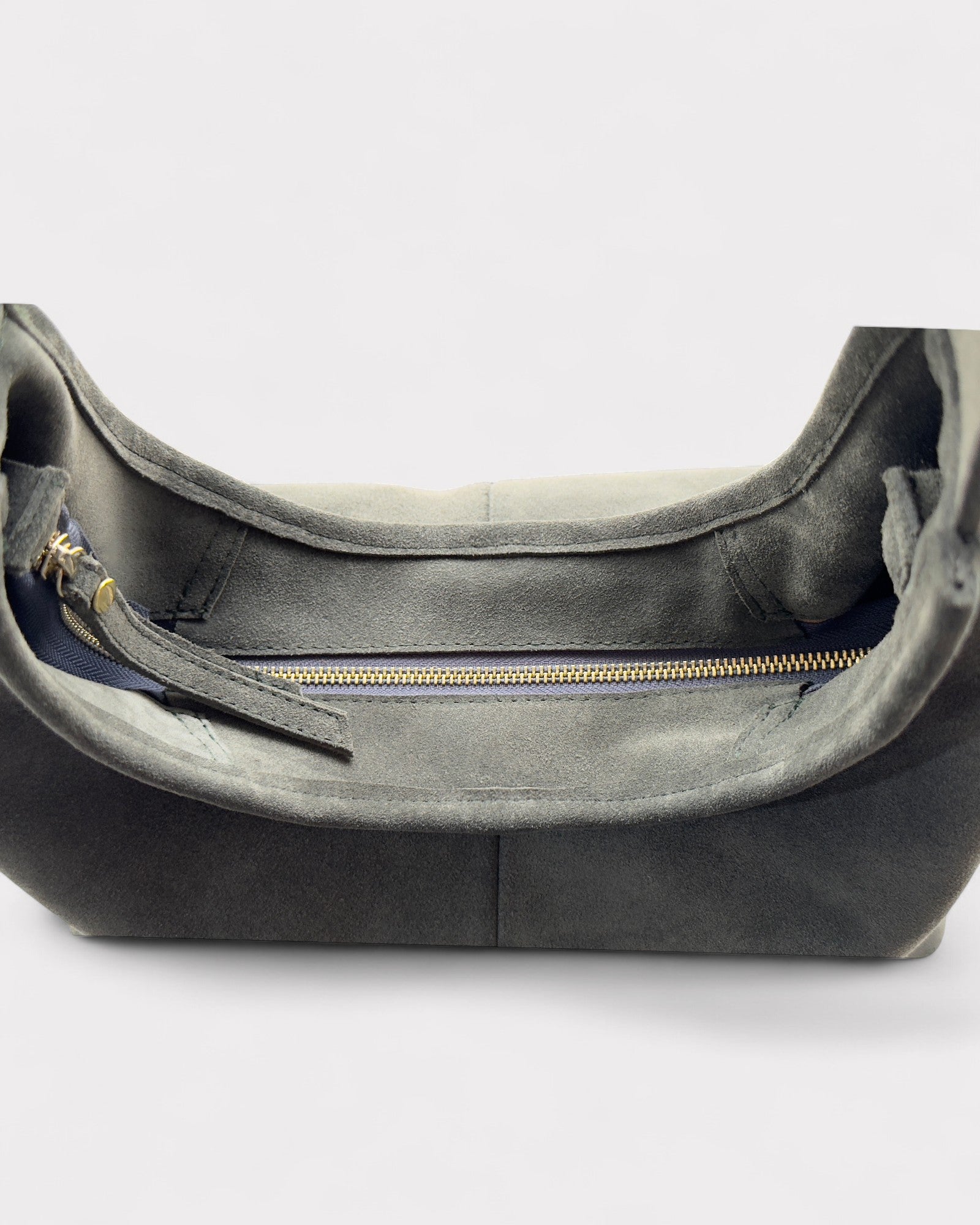 Green leather handbag with a gold zipper on a white background