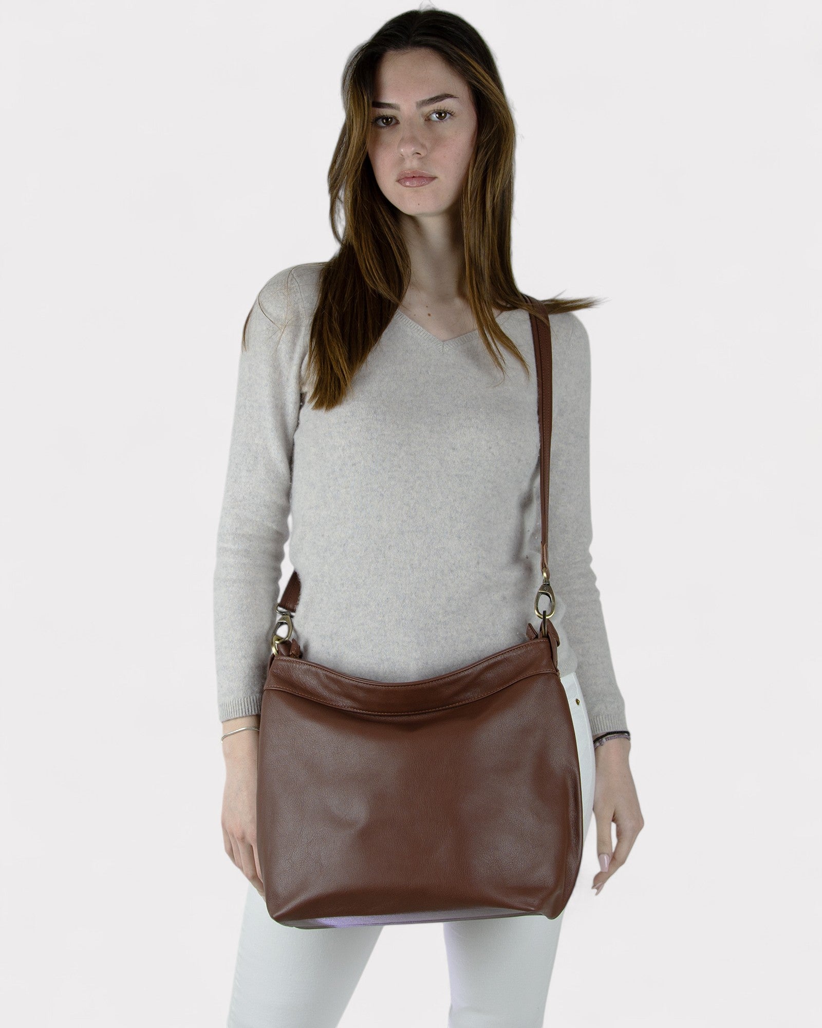 Woman carrying a brown leather bag on a white background