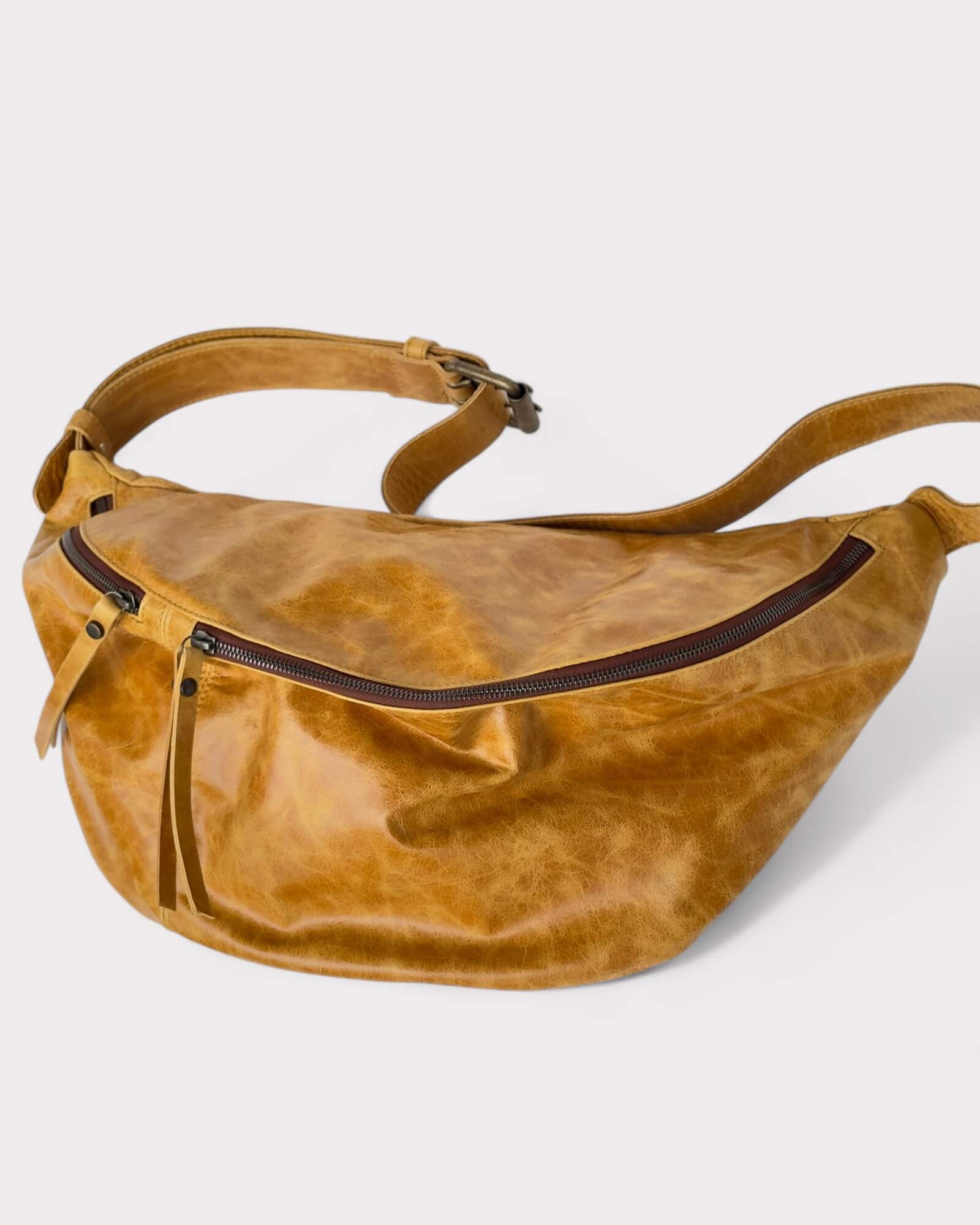 Tan leather waist bag on a light gray background