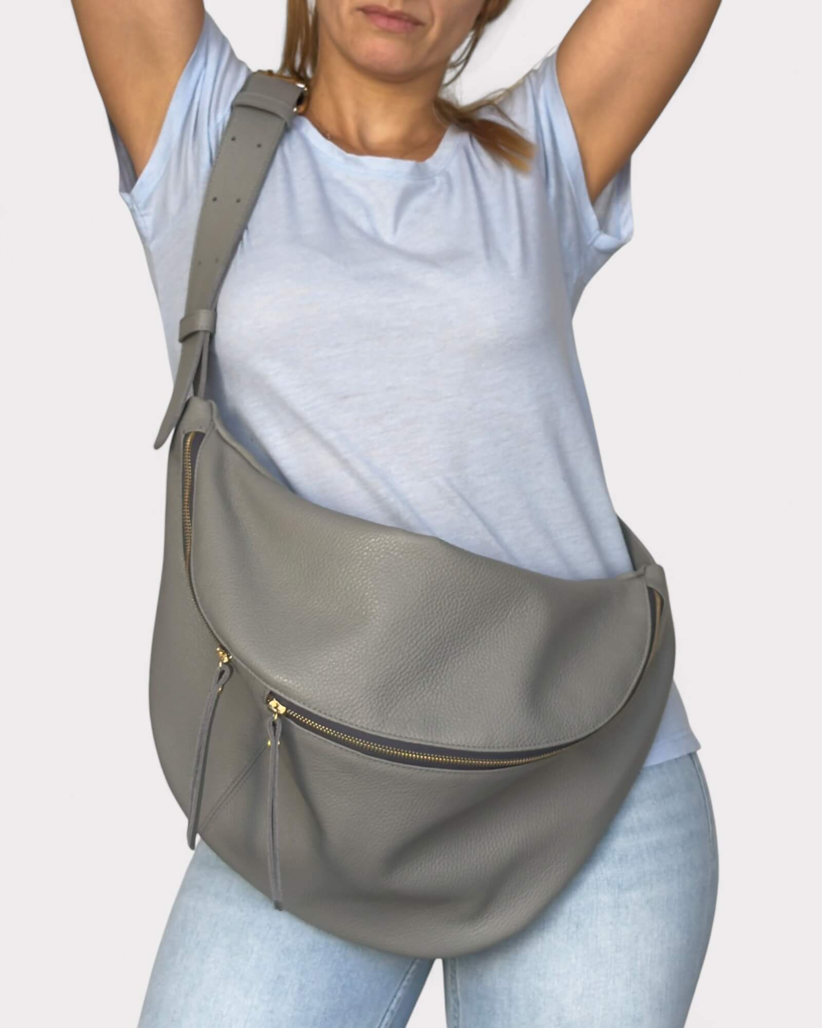 Person wearing a gray chest bag on a plain background