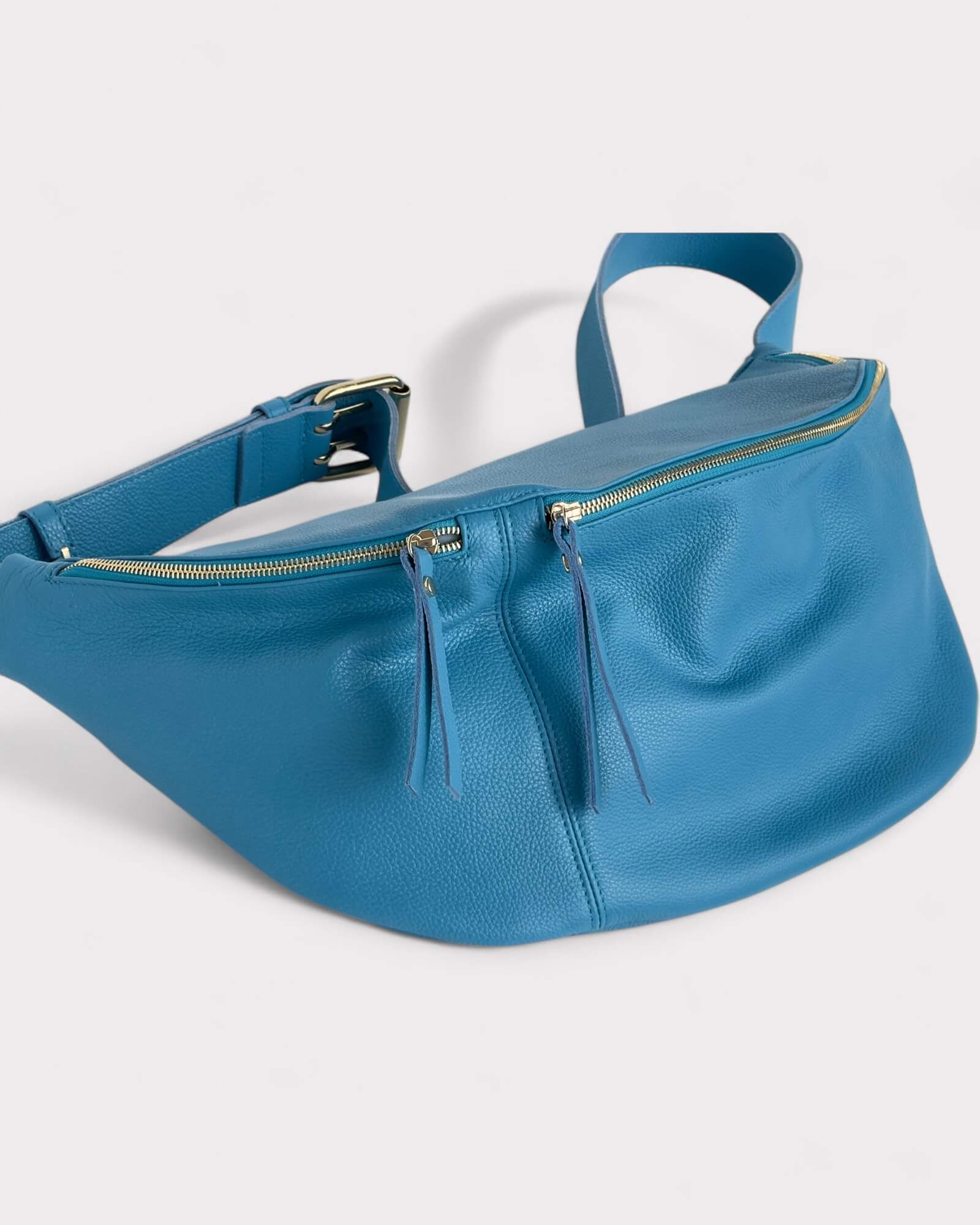 Blue leather waist bag on a white background