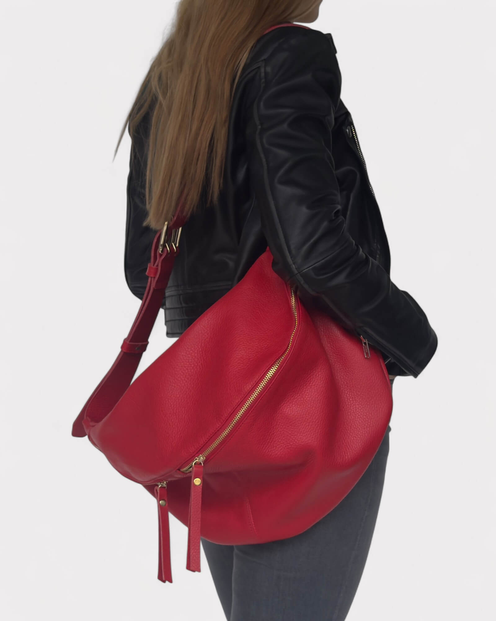 Model wearing a black leather jacket with a red fanny pack on a white background