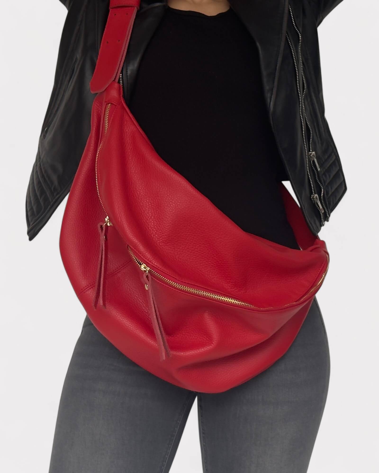 Red leather bag worn over shoulder on a plain background