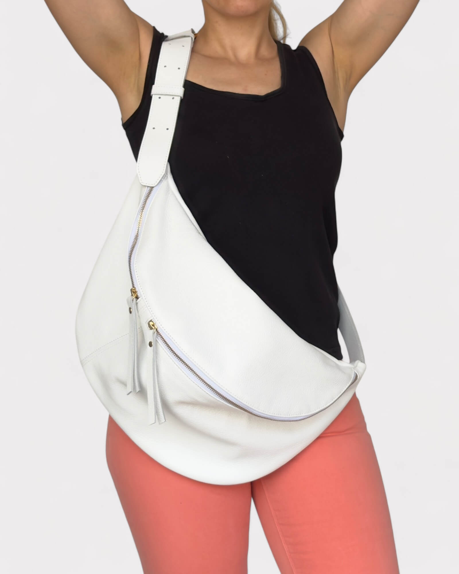 Person wearing a white sling bag on a plain background