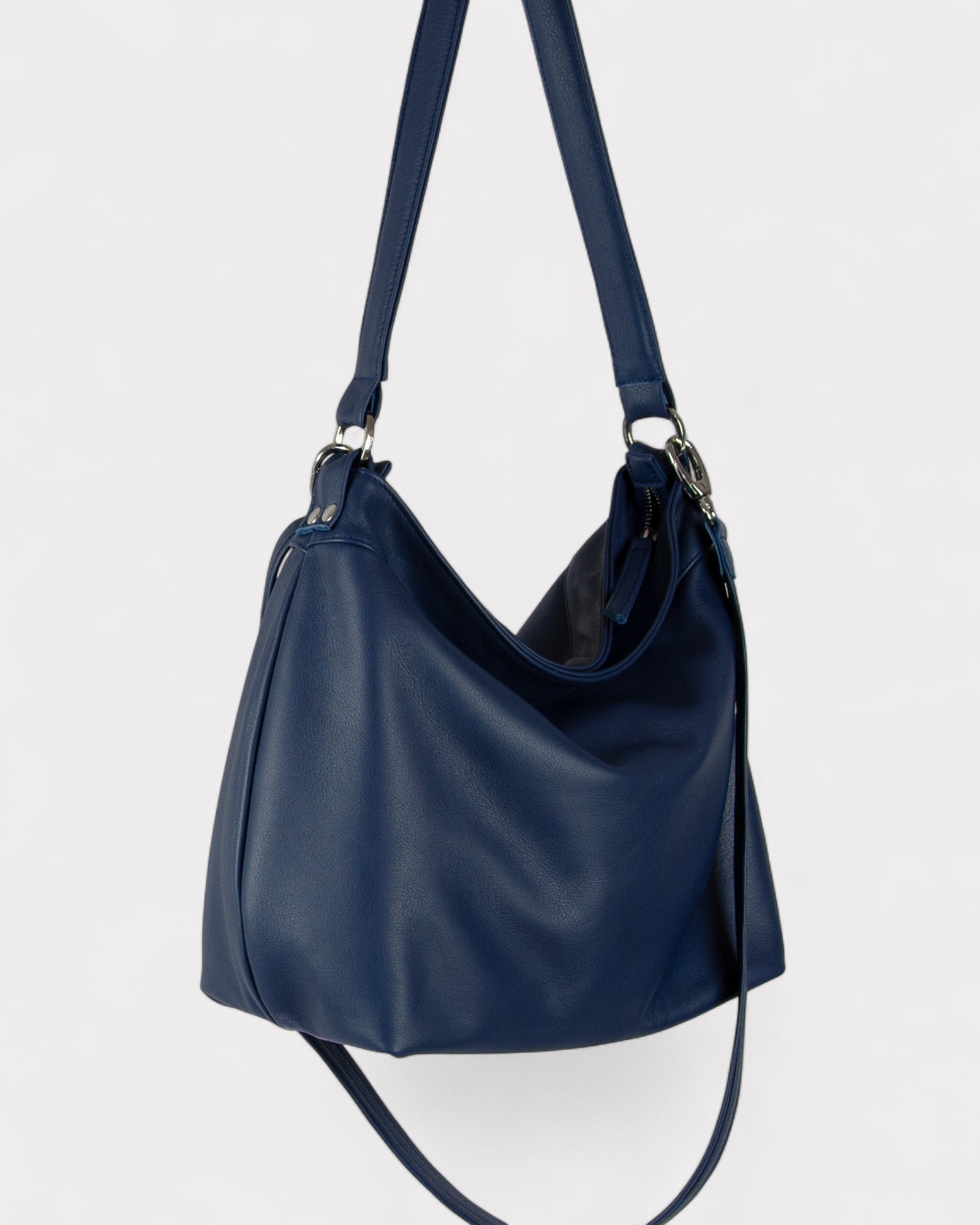 Navy blue handbag with a shoulder strap on a light gray background