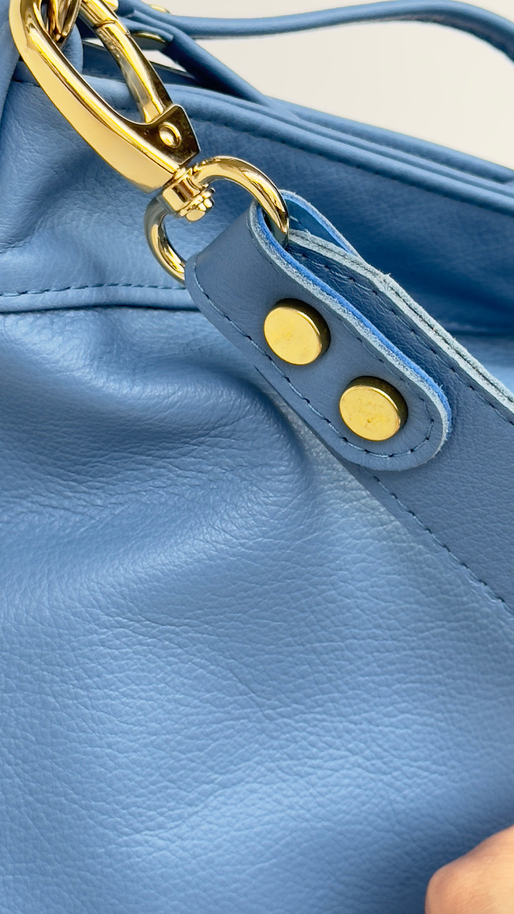 Close-up of a blue leather bag with gold hardware