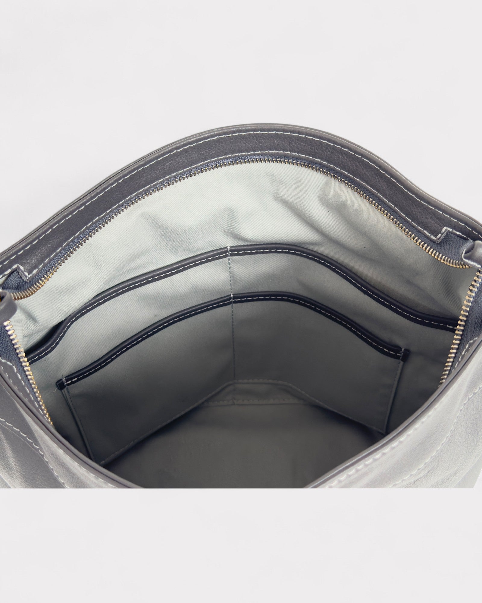 Gray bag interior with visible stitching on a light gray background