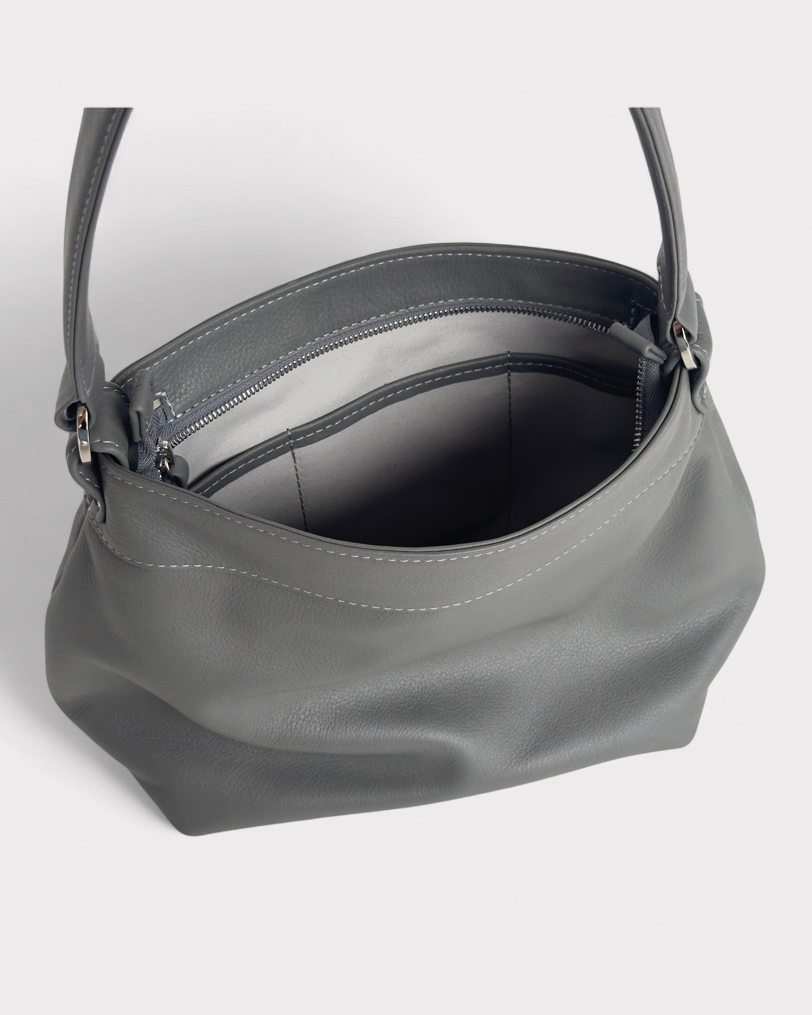 Gray handbag with a shoulder strap on a light gray background