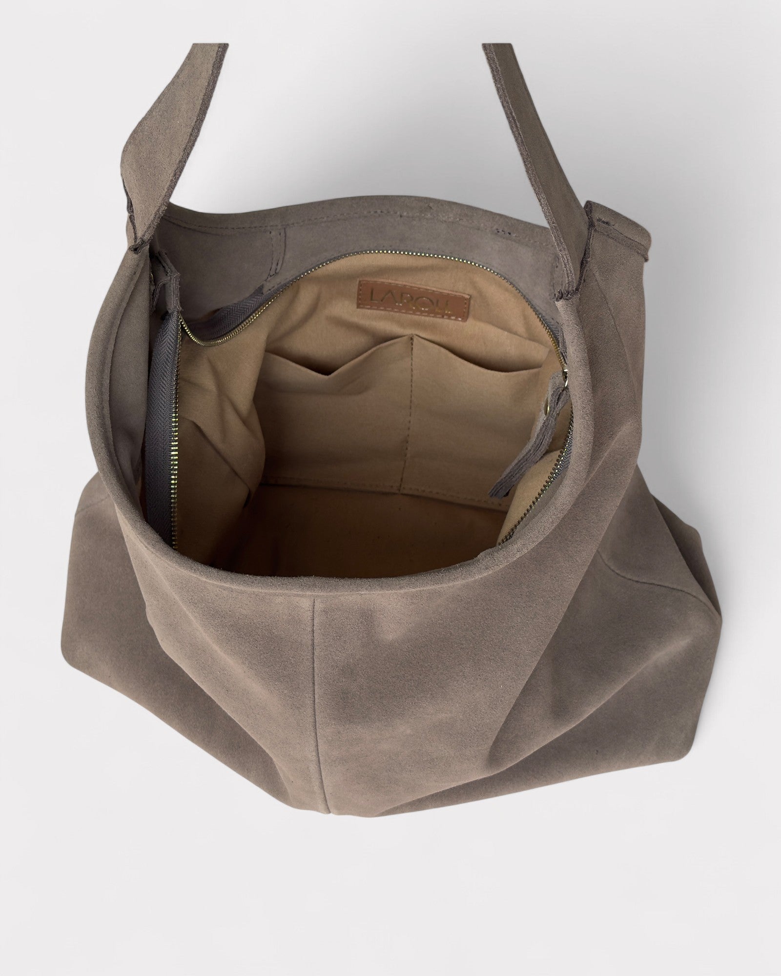 Taupe leather bag with a visible brand label on a white background