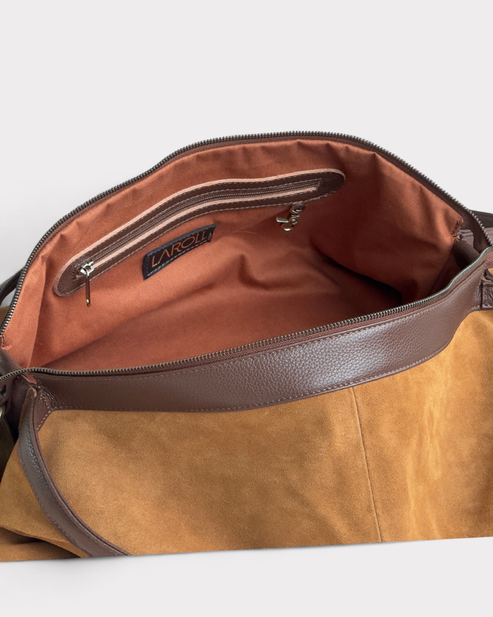 Tan leather bag with visible brand logo on a light gray background