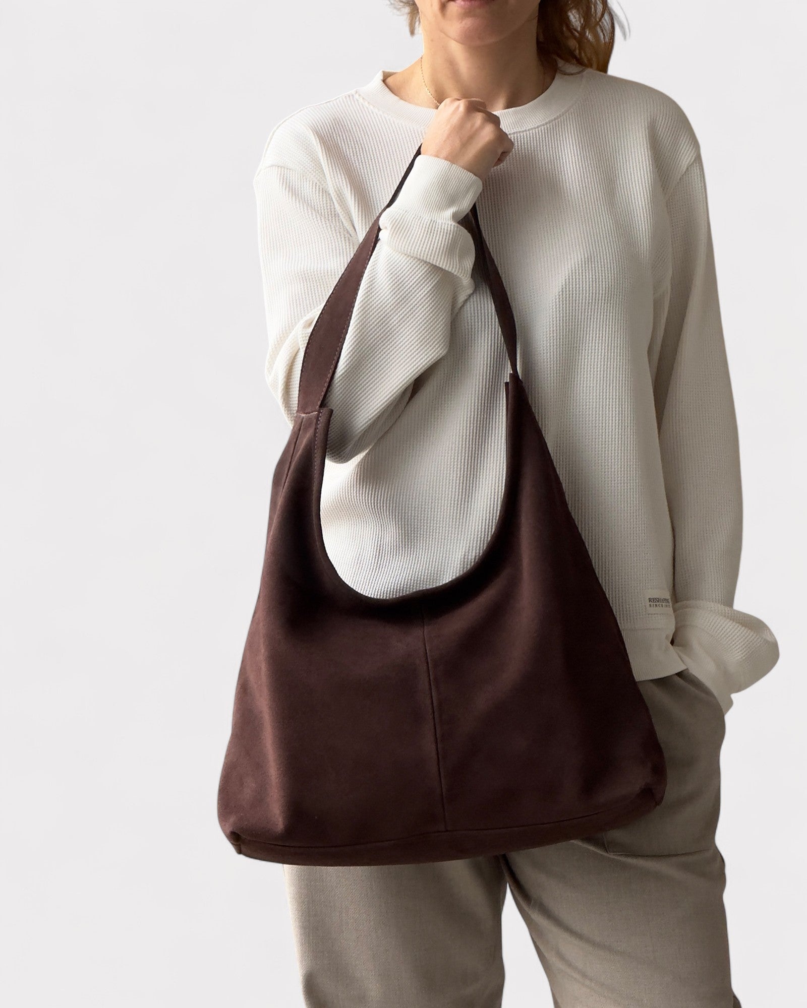 girl wearing dark brown suede bag