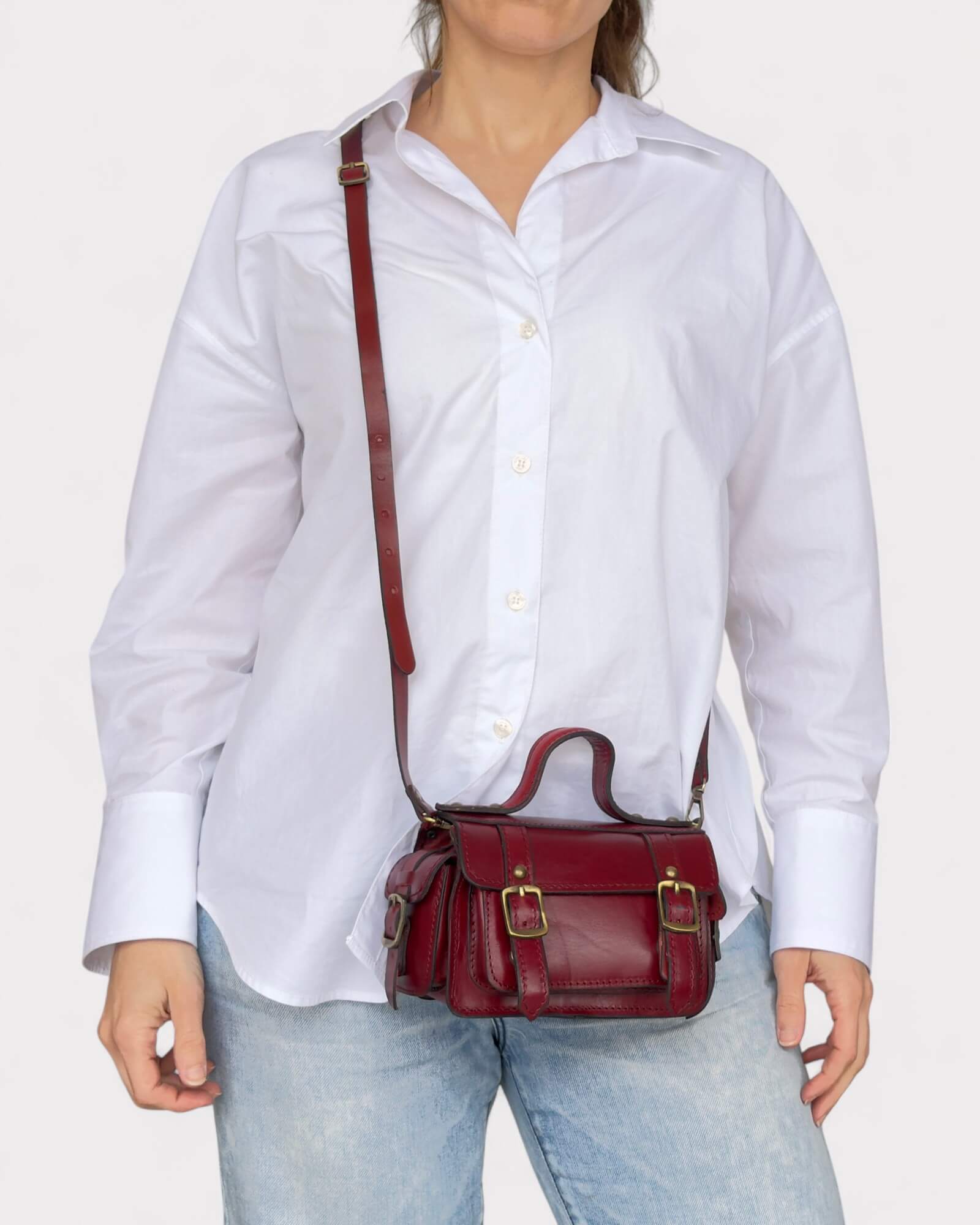 model carrying red crossbody satchel across the body