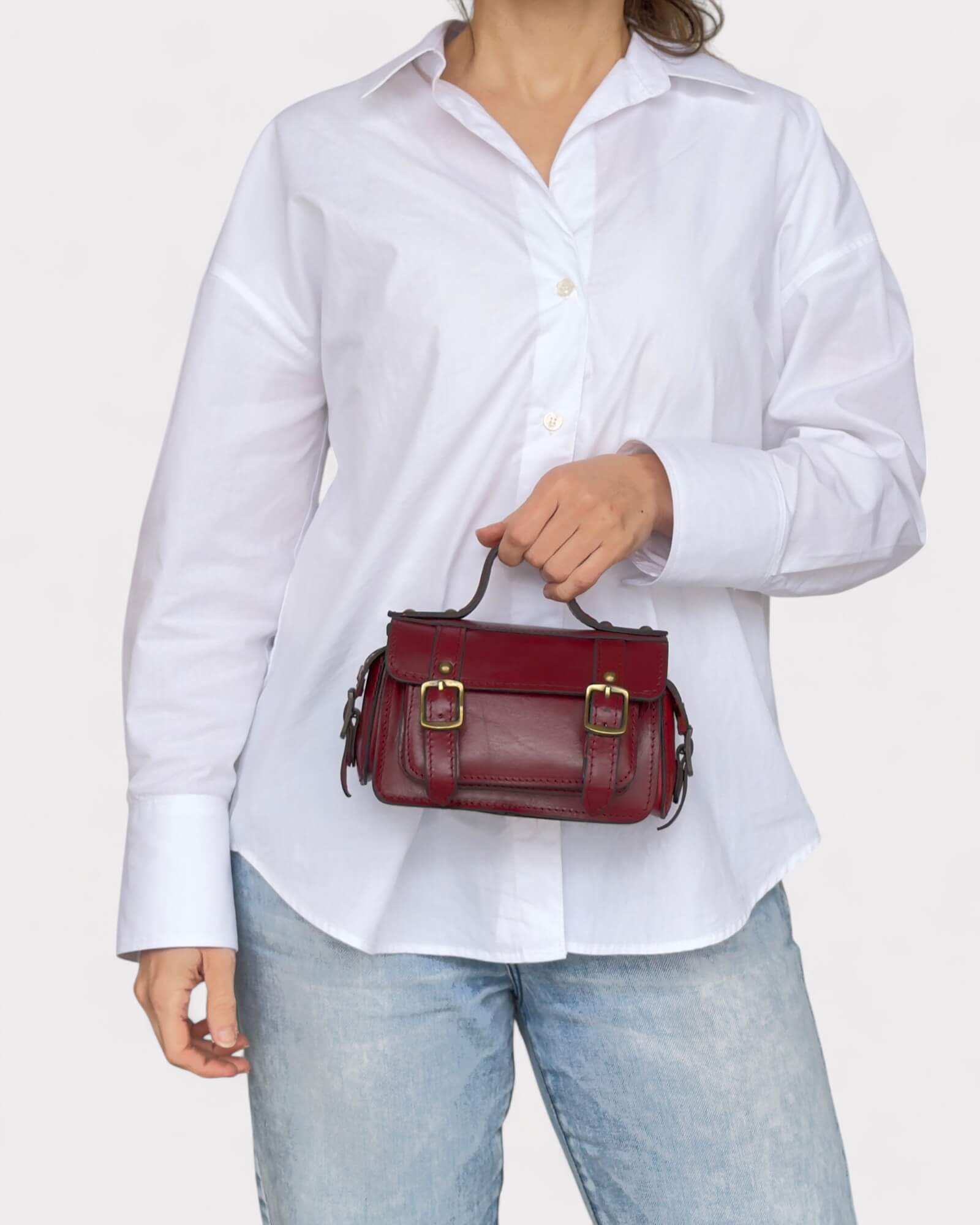 model holding red crossbody satchel in front of her body