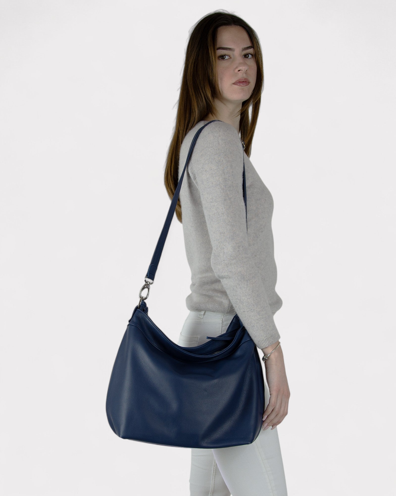 Woman carrying a navy blue handbag on a white background