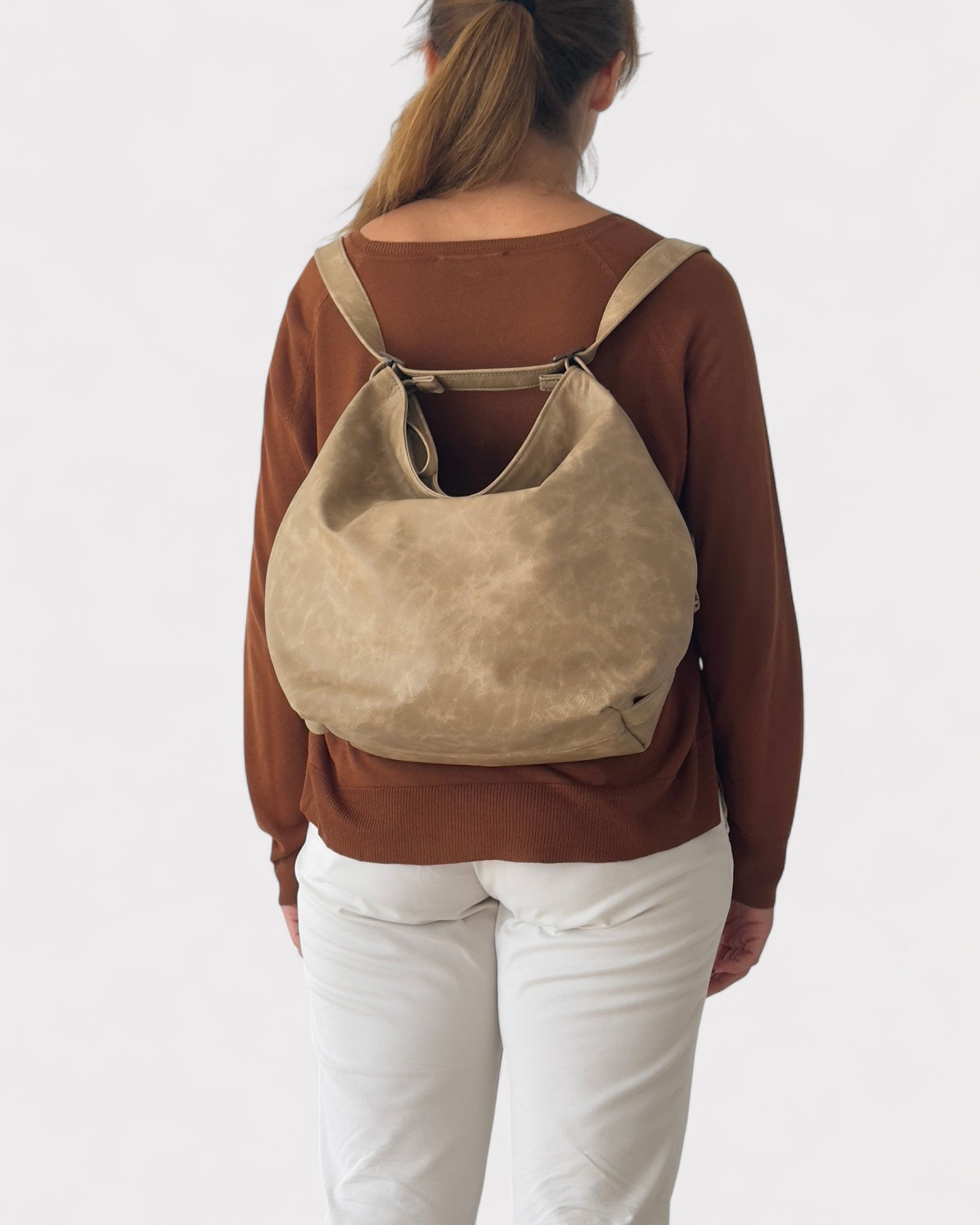 model wearing convertible hobo bag as backpack