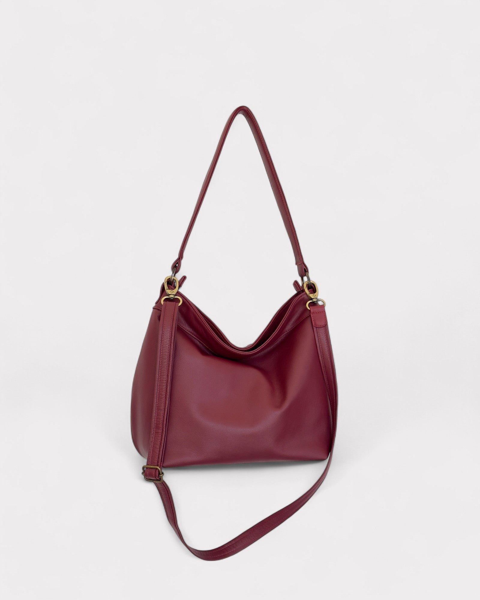 Red handbag with brass hardware on a light gray background