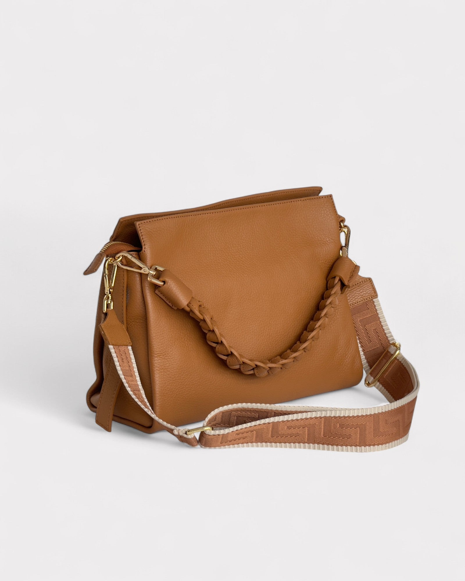 Tan leather handbag with a chain detail on a light gray background