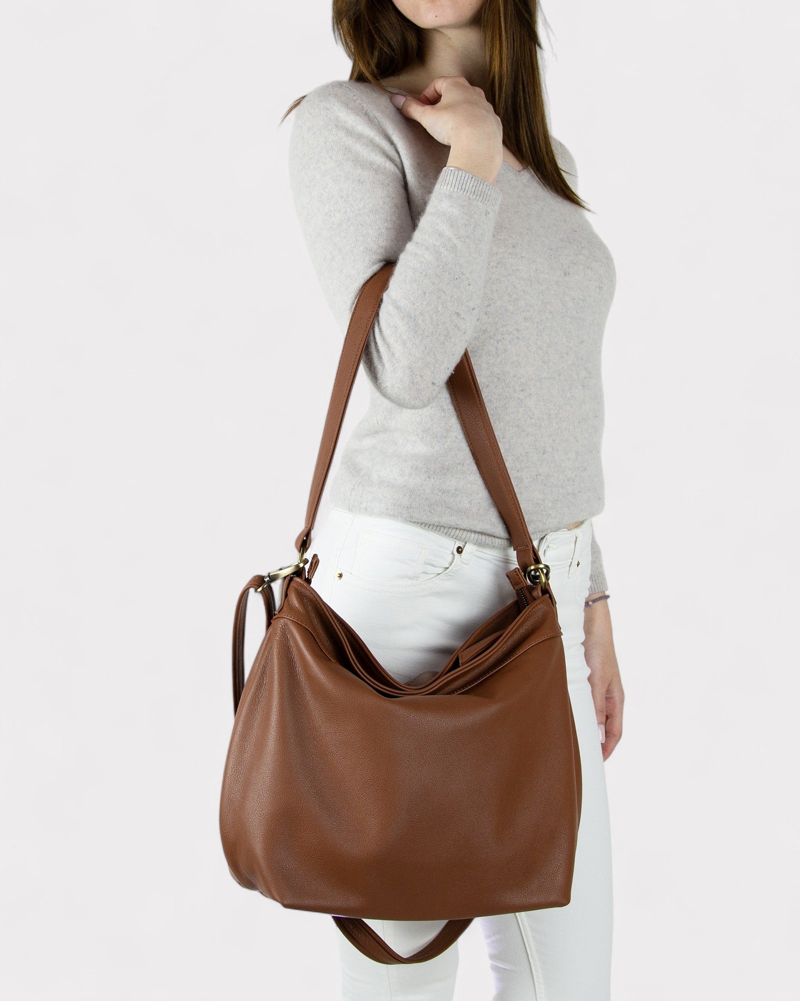 Person wearing a Cognac brown shoulder bag on a white background